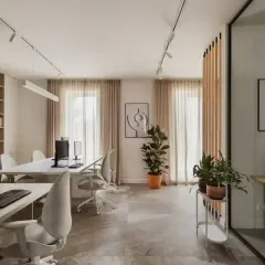 Nowoczesne biuro z biurkami, komputerami i roślinami.