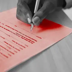 Dłoń podpisuje umowę o współpracę między firmami. Dokument zawiera pola na datę i podpisy.