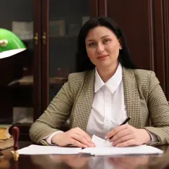 Kobieta w biurze analizuje dokumenty, zastanawiając się, ile zarabiają adwokaci.