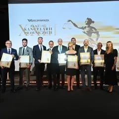 Grupa prawników odbiera nagrody na scenie przed ekranem z logo "Rzeczpospolitej" i grafiką Temidy.