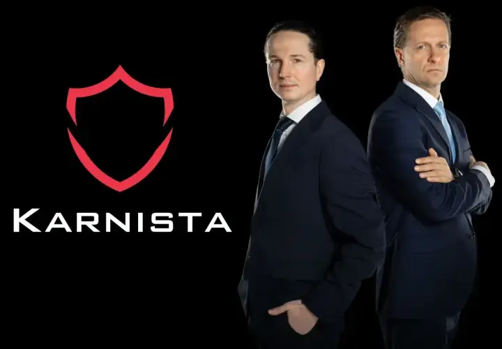 Dwaj mężczyźni w garniturach stoją obok logo "KARNISTA" na czarnym tle.