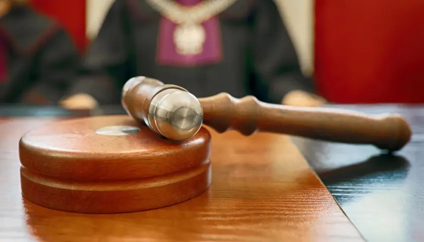 Młotek sędziowski na stole. Sąd rozstrzyga, czy odpowiedź na apelację doręcza się bezpośrednio pełnomocnikowi.