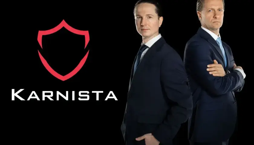 Dwaj mężczyźni w garniturach stoją obok logo "KARNISTA" na czarnym tle.