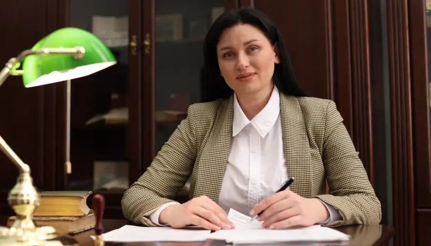 Kobieta w biurze analizuje dokumenty, zastanawiając się, ile zarabiają adwokaci.