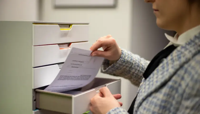 Kobieta przegląda dokumenty, szukając informacji, jak napisać apelację do sądu.