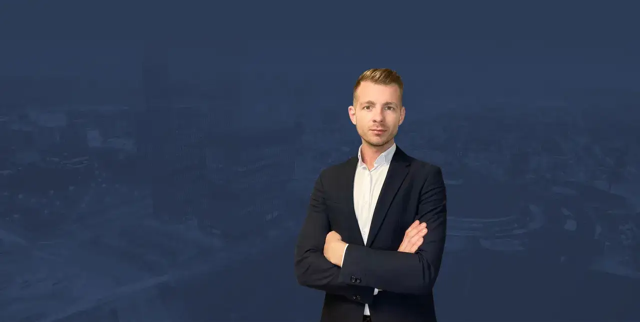 Mężczyzna w garniturze na tle panoramy Katowic.