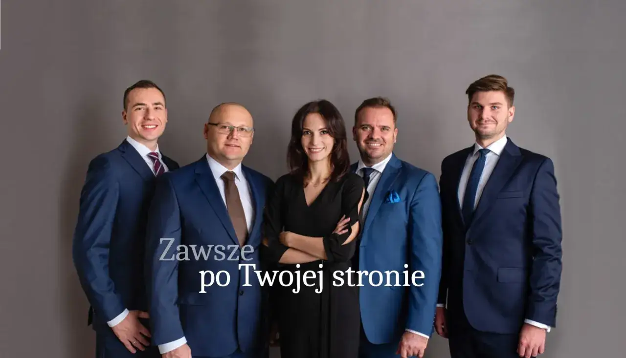Pięć osób w garniturach, w tym jedna kobieta, pozuje do zdjęcia na szarym tle.
